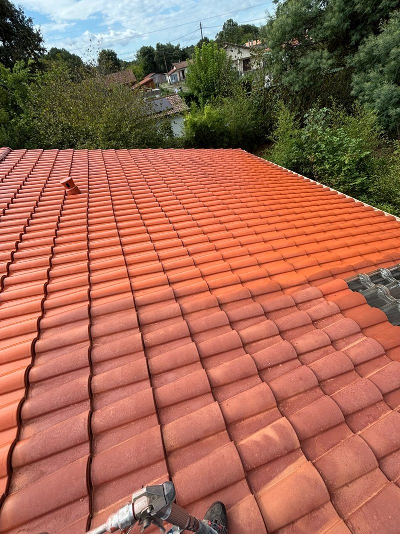 Application de peinture de toiture au pistolet, chantier en cours